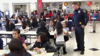 Police officer speaking with students in a cafeteria