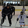Tournament and Ville Deux-Montagnes Officer Chris Harding teaching a child to skate as part of the Les Forces police hockey program