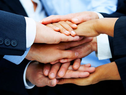 Image of hands stacked together to represent partnership