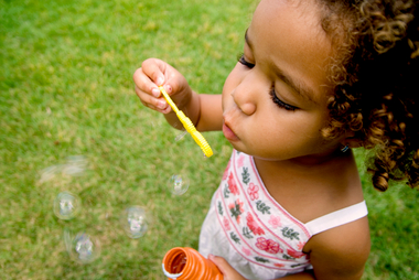 image of little girl blowing bubbles