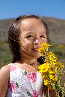 image of little girl smelling flowers