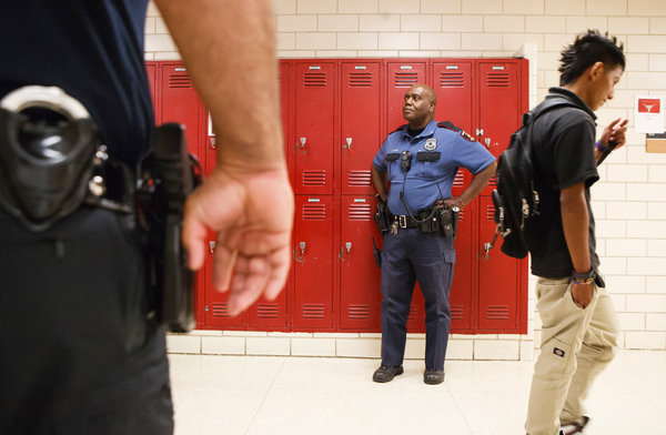 cop and student walking in a hallway