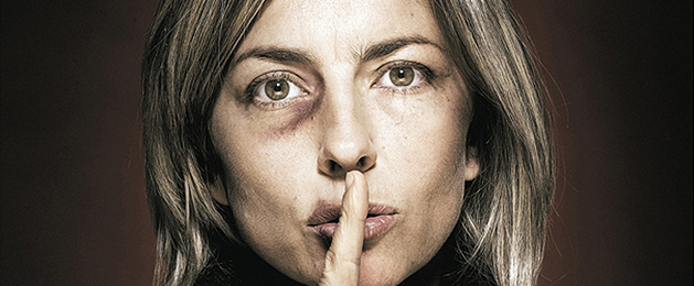 photo of a woman with a black eye and a finger over her lips
